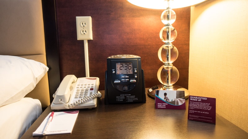 NIghtstand with lamp, telephone, pen and paper, and CD player alarm clock
