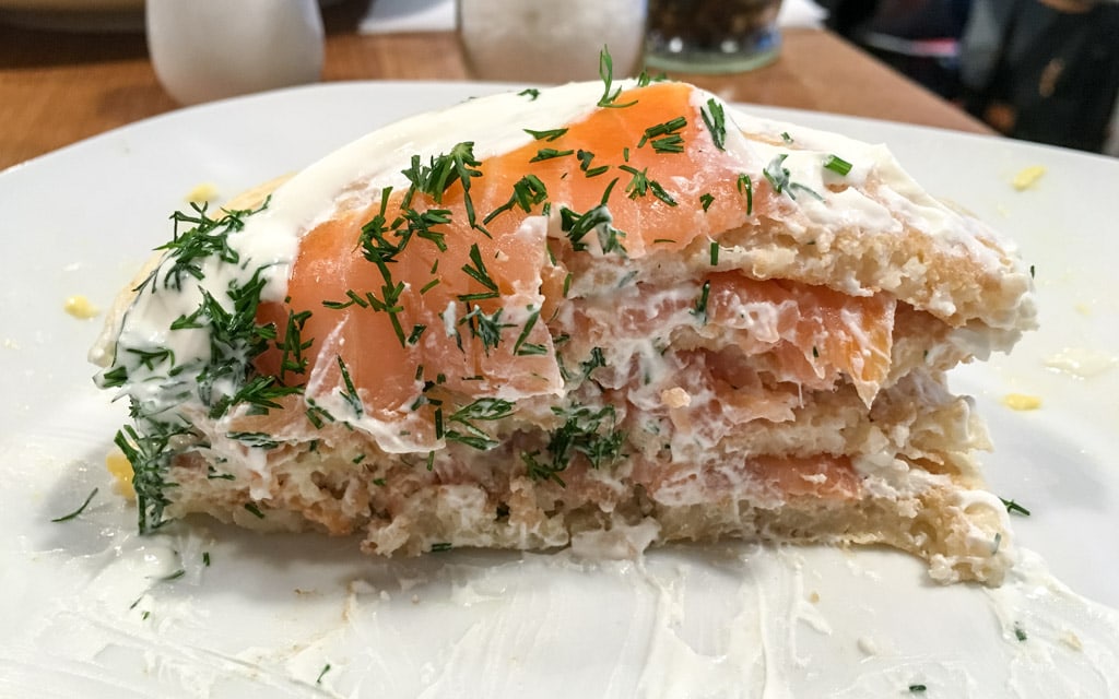 Layer after layer of pancakes, salmon, sour cream, and dill