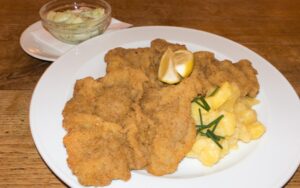 Wiener Schnitzel with potato salad and cucumber salad on the side from Prater Garten, Berlin