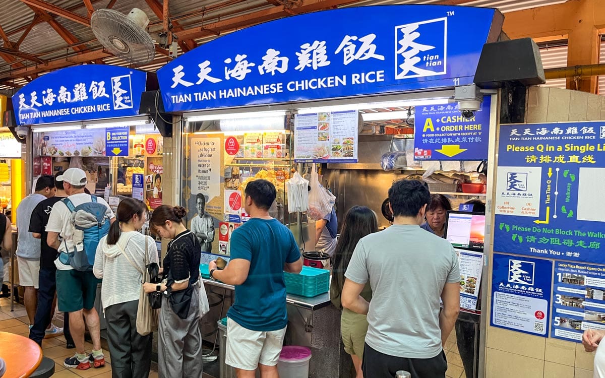 People ordering food under a sign that says A and then walking down to where it says B to collect food