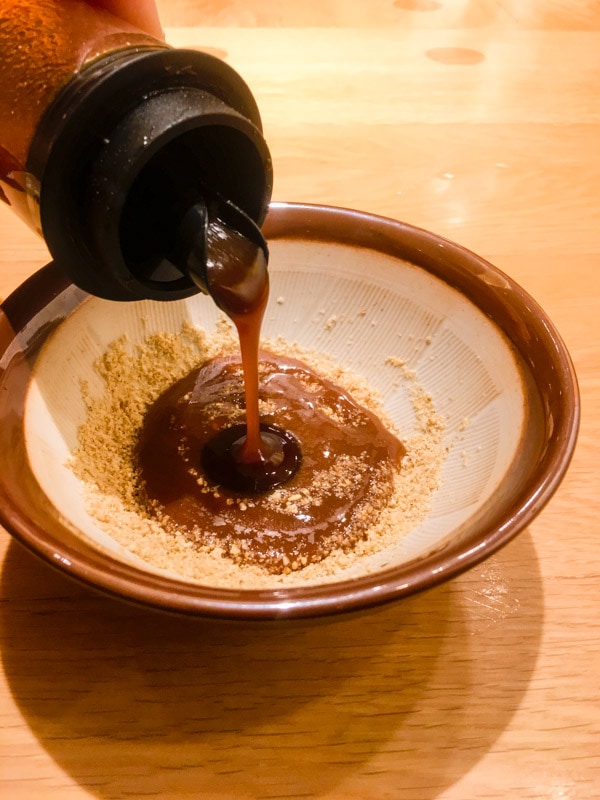 Pouring cutlet sauce into sesame seeds, Katsukura, Kyoto, Japan