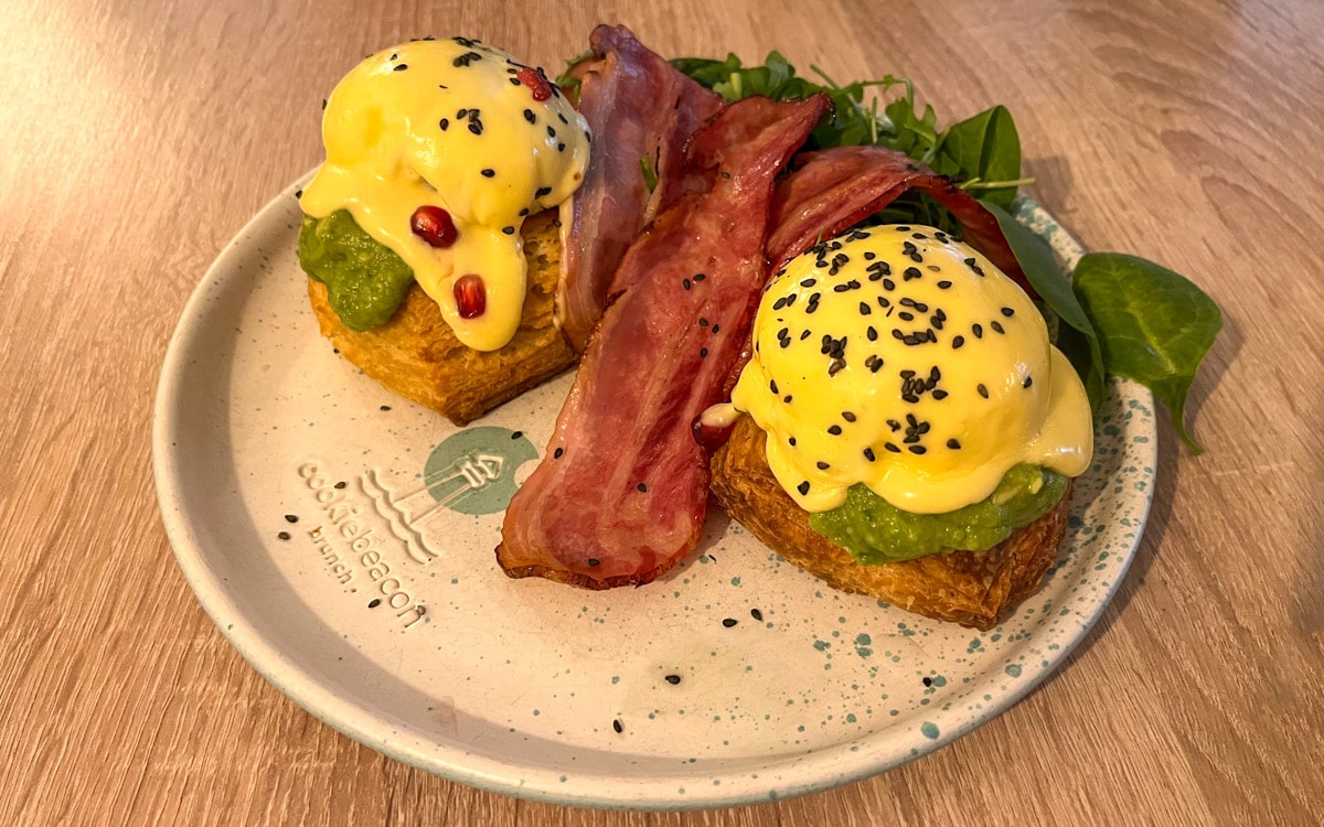 Eggs Benedict on Biscuit & Avocado with a side of bacon, Cookie Beacon in Budapest, Hungary