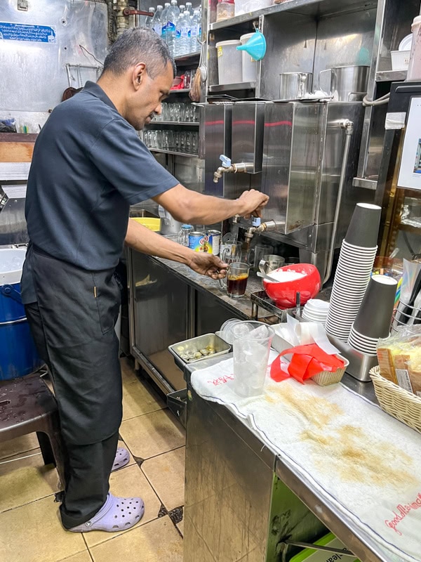 The man operating Bismi Tea Stall seen preparing a glass of tea